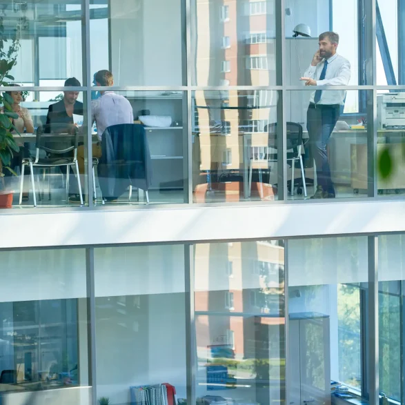 Bâtiment de bureaux équipé de films solaires anti-chaleur, avec employés travaillant à l’intérieur, bénéficiant d’un confort thermique optimal